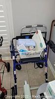 Photo showing a blue walker frame with no basket or attached items. The basket placed on the walker is not included in the sale.