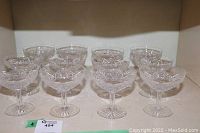 12 cut glass champagne glasses arranged in rows showing their starburst and geometric cut design