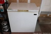 White Kenmore small chest freezer, front and top view, showing control panel on lid.