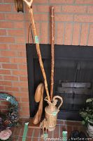 Photo showing the wood farmer figurine, carved jug, and two walking sticks against a fireplace backdrop.