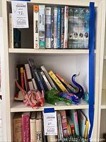 Shelf with VHS tapes and DVDs at top, including travel and documentary titles