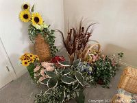 Overall view of large variety of faux botanical decor with sunflowers, leafy plants, and floral arrangements in baskets and pots.