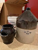 Stoneware crock marked '2' with a brown pottery jug beside it.