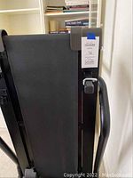 Folded Weslo treadmill viewed from top showing narrow treadmill walking surface and foldable arms with grey locks