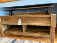 Wide angle photo of the front of the coffee table showing open lift top and bottom shelf
