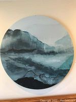 Full frontal view of round abstract ocean painting in blues and greens