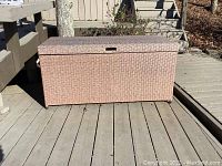 Closed view of the faux wicker storage box on outdoor wooden deck