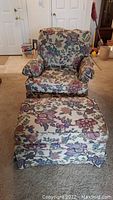 Floral upholstered Ethan Allen chair and ottoman set showing front view of the chair and ottoman with visible sun fading