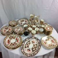 Overview of entire 74-piece Aynsley Imari bone china set arranged on white cloth