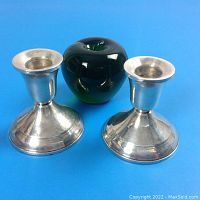Pair of sterling silver candlesticks side by side with a green apple for size reference.