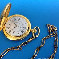 Caravelle pocket watch open showing white Roman numeral dial and gold-tone hands