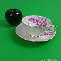 Cup and saucer set with green apple for 3" size reference