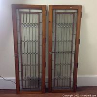 Full view of both cabinet doors leaning against wall showing overall design and dimensions