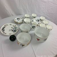 Full set view showing Wedgwood dishes and three additional serving bowls alongside green glass apple for size reference.