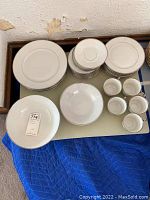 Photo of stacked plates, teacups and saucers shown from top view laid on table.