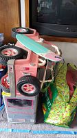 Side view of pink toy car with attached surfboard and packaging materials