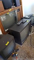 Photo showing multiple CRT TVs together, with Sony and Emerson TVs visible, some remotes and cables also shown.