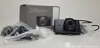 Photo showing the Apeman C450 dash camera, its packaging box, and cables all in plastic bags.