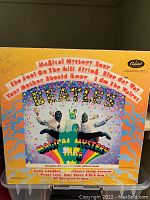Front cover of The Beatles Magical Mystery Tour album showing colorful psychedelic artwork, band members, and Capitol Records logo.