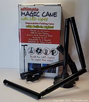 Photo of the Ultimate Magic Cane box and the unfolded cane showing its sections, wide base, and built-in LED lights.