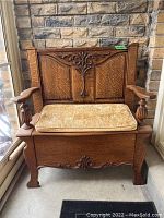 Front view of oak bench with beige patterned cushion installed