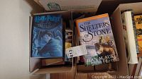 Box of assorted books including 'Harry Potter and the Prisoner of Azkaban' and 'The Shelters of Stone' by Jean M. Auel.