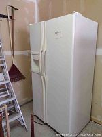 Side view of the white GE Profile side-by-side refrigerator freezer showing its full height and doors.