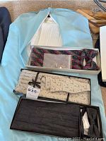 Three boxes containing ties and cummerbund sets; one set includes cufflinks.