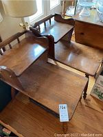 Pair of vintage solid wood end tables stacked, showing the wood surface and raised edges on one side