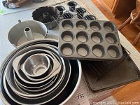 Overview of all nested stainless bowls, muffin pans, Bundt pans, popover pan, wire racks, and baking sheets.