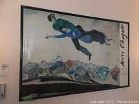 Full view of framed Marc Chagall print showing two floating figures above a village with artist's name and exhibition text