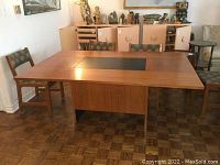 Front view of teak dining table with black central insert closed