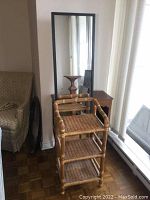 Full length mirror in dark wood frame positioned behind the wicker shelf showing the overall height and frame style