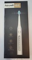 Photo of the Fairywill D7 electric toothbrush box showing the product image and features including smart timer, 5 modes, long standby period, and fast charge