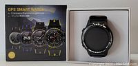 Photo showing GPS smart watch in box with outer packaging depicting various models and features