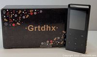 Black Grtdhx branded box and the black MP3/MP4 player with touchscreen buttons and display.
