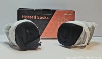Pair of rolled black ISOPHO heated socks with original box behind them, box shows ISOPHO branding and 'Heated Socks' text.