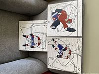 Three hockey canvas prints showing red, white, and blue uniformed players on a gray background with hockey play markings.