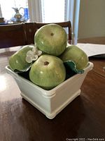 Image of hand-painted porcelain basket with life-like green apples, showing top-down view and apple detail with leaves and flowers.