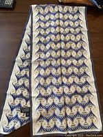 Photo of the scarf laid flat showing full length and repeating pattern.