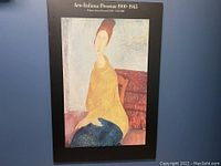 Front view of the Modigliani print on hard board showing the portrait and surrounding black border with text at the top.