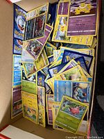 Top view of cardboard shoebox filled with assorted Pokémon TCG cards