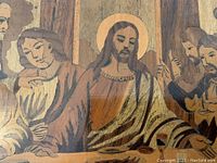 Close-up photo showing detailed wood inlay of Jesus and disciples from The Last Supper, capturing the intricate craftsmanship and warm color tones.