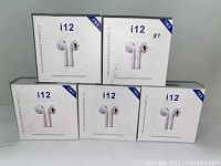 Five boxes of i12 wireless stereo earbuds stacked in a 3 and 2 formation, showing the front of the packaging with images of the earbuds and key features including Bluetooth 5.0 and TWS technology.