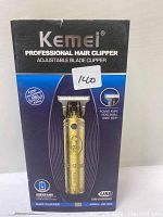 Photo of Kemei Professional Hair Clipper box showing product image and features including adjustable blade, USB charging, and model KM-7000.