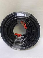 Photo showing the full coiled black outdoor Cat 7 Ethernet cable with visible red RJ45 connectors.