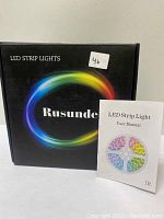 Box of Runsunde LED strip lights with colorful circular design and user manual displayed in front.