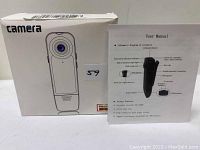 Product box with image of the spy camera and user manual showing diagram of the device's features.