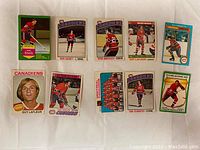 Front view of 10 vintage 1970s Montreal Canadiens hockey cards showing players like Guy Lafleur, Bob Gainey, team photo and more with varied colorful borders.