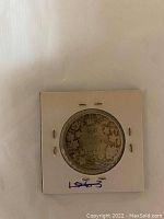 Reverse side showing '50 CENTS' denomination with maple leaf design and crown, coin inside white paper holder.